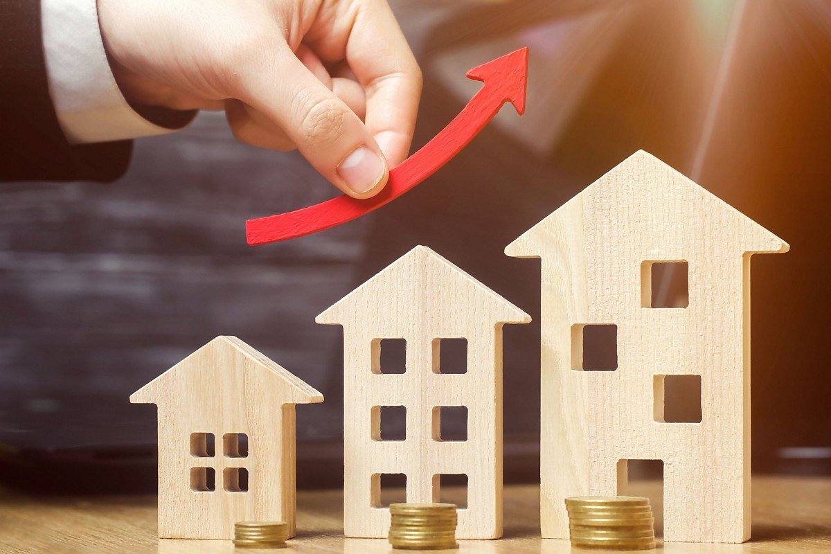 Hausverwalter optimiert Mietenrendite mit H�usern und M�nzen als Symbol f�r professionelle Immobilienverwaltung und finanzielle Planung